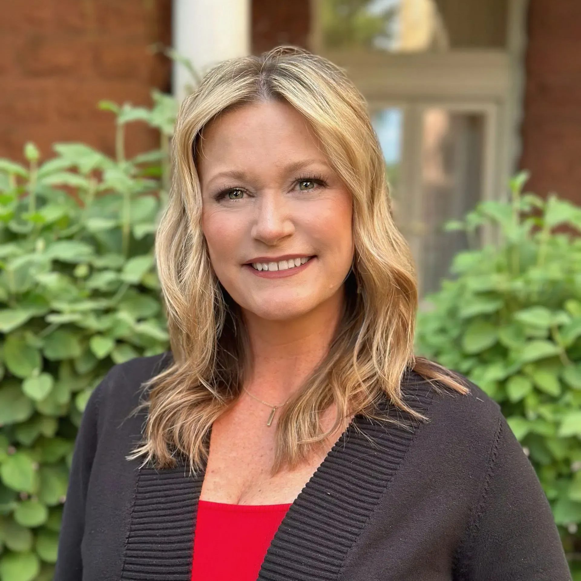 A man is holding a dog in his arms and the dog is wearing a sweater.