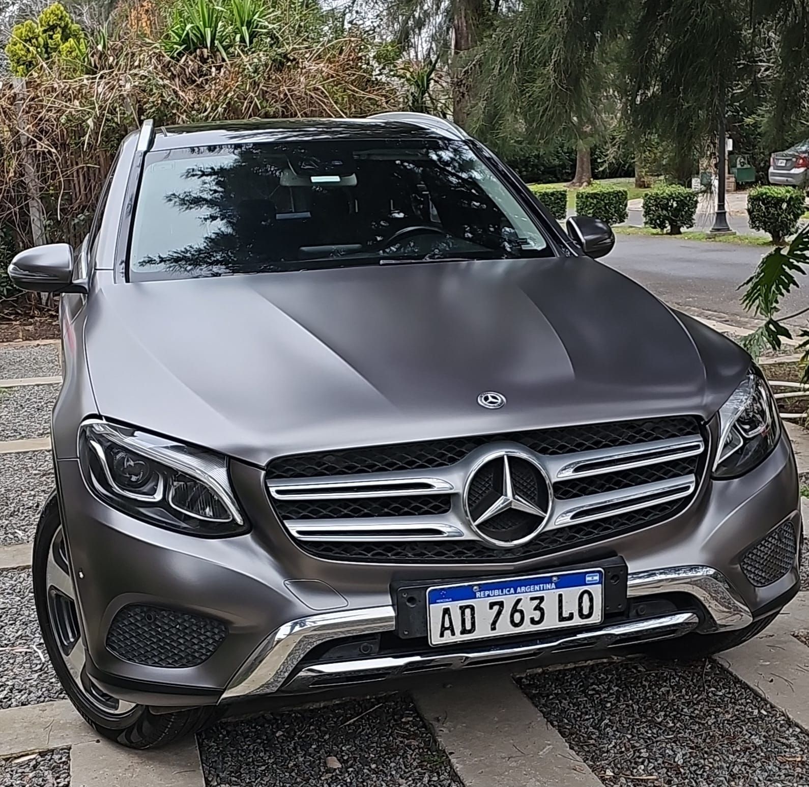 SUV Mercedes-Benz de color gris con matrícula argentina estacionado en un camino de grava.