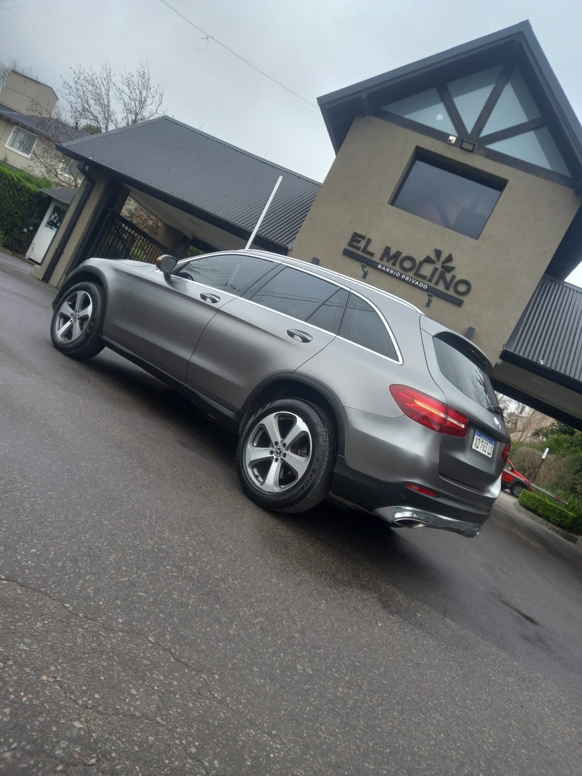 Camioneta Mercedes color gris estacionada frente a un edificio con la leyenda 