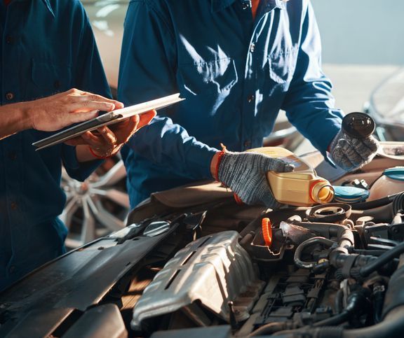 Auto Mechanics Performing Oil Change Service