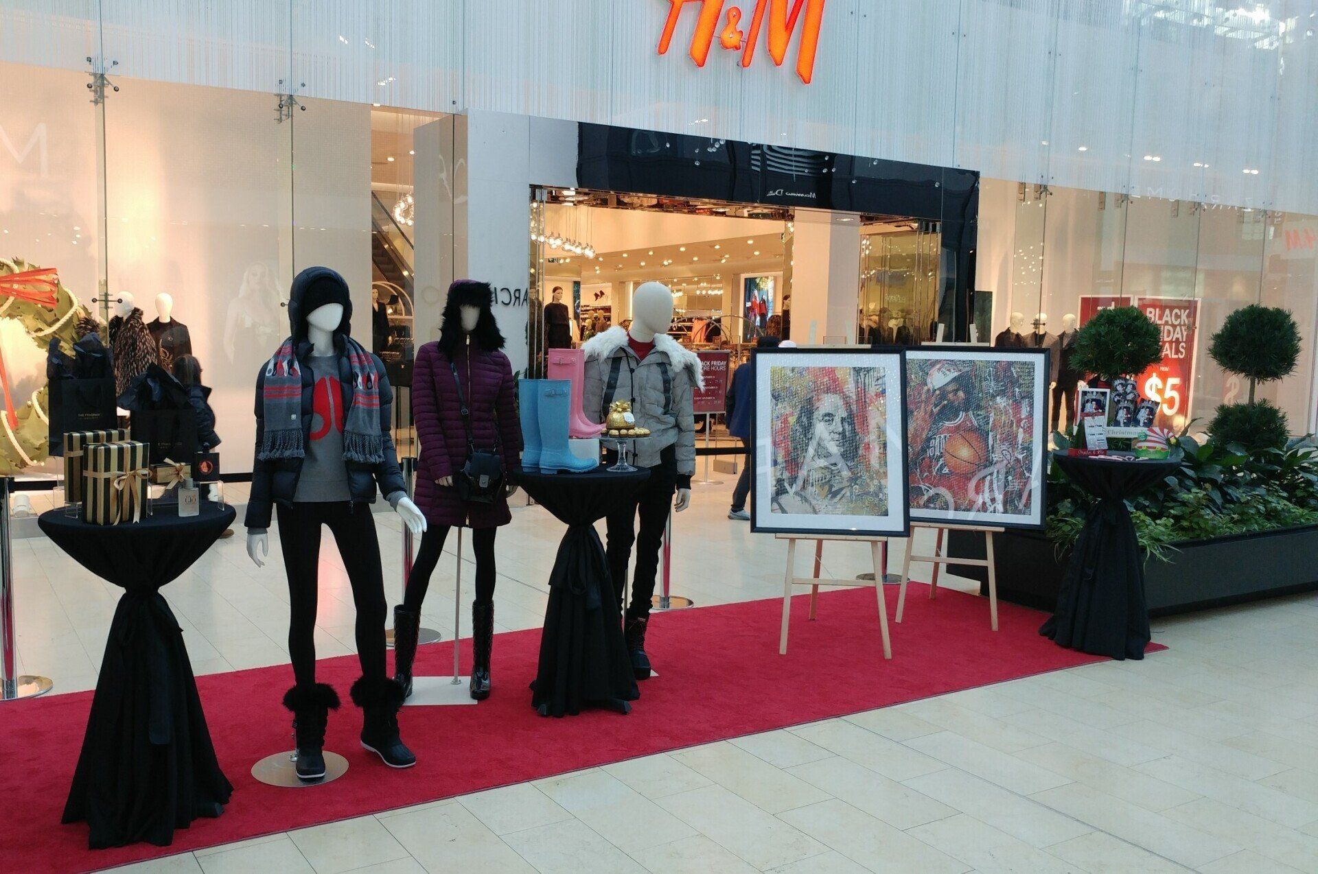 Mannequins are displayed in front of a h & m store