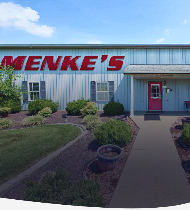 Menke's building with red sign, blue exterior, and a red door.  | Menke's Automotive Repair