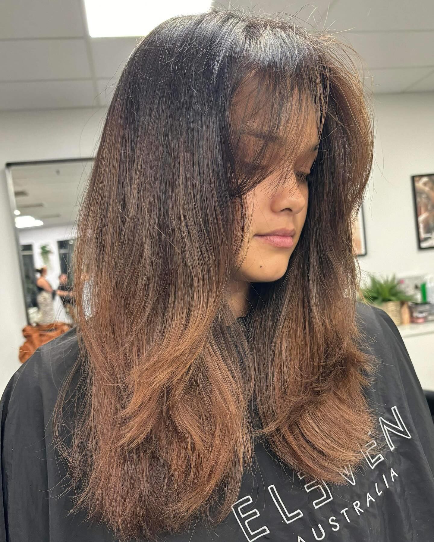 A Woman With Purple Hair is Standing in Front of a Mirror — Fusion Hair In Woree, QLD