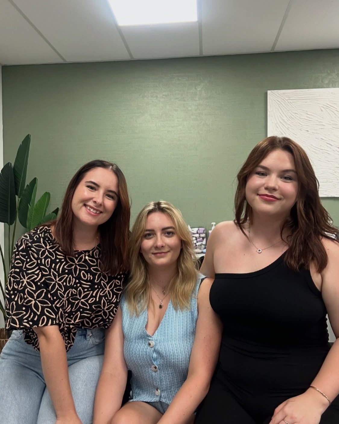 Three women are sitting next to each other in a room — Fusion Hair In Woree, QLD