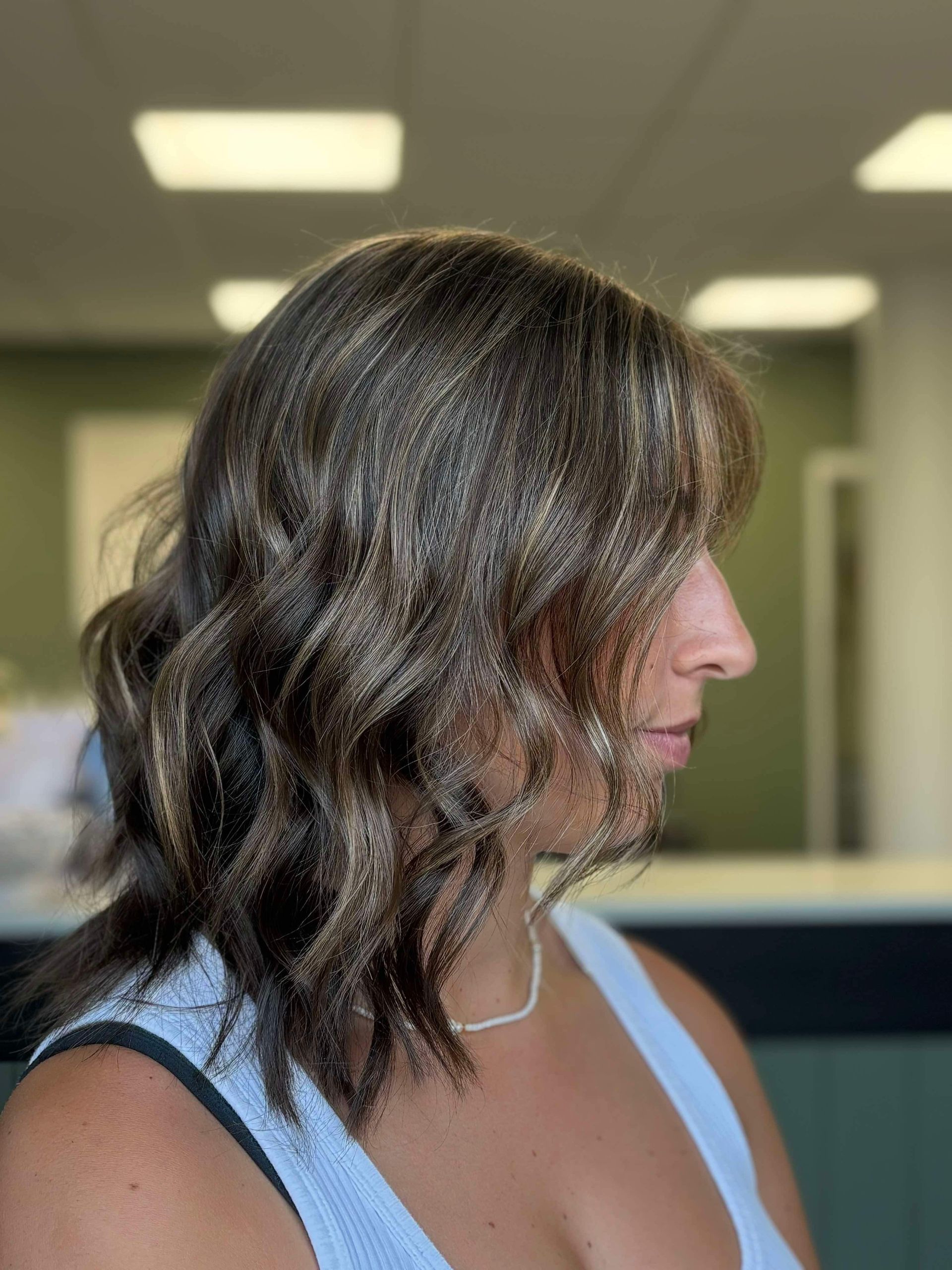 A Woman With Long Brown Hair is Wearing a Blue Shirt — Fusion Hair In Woree, QLD