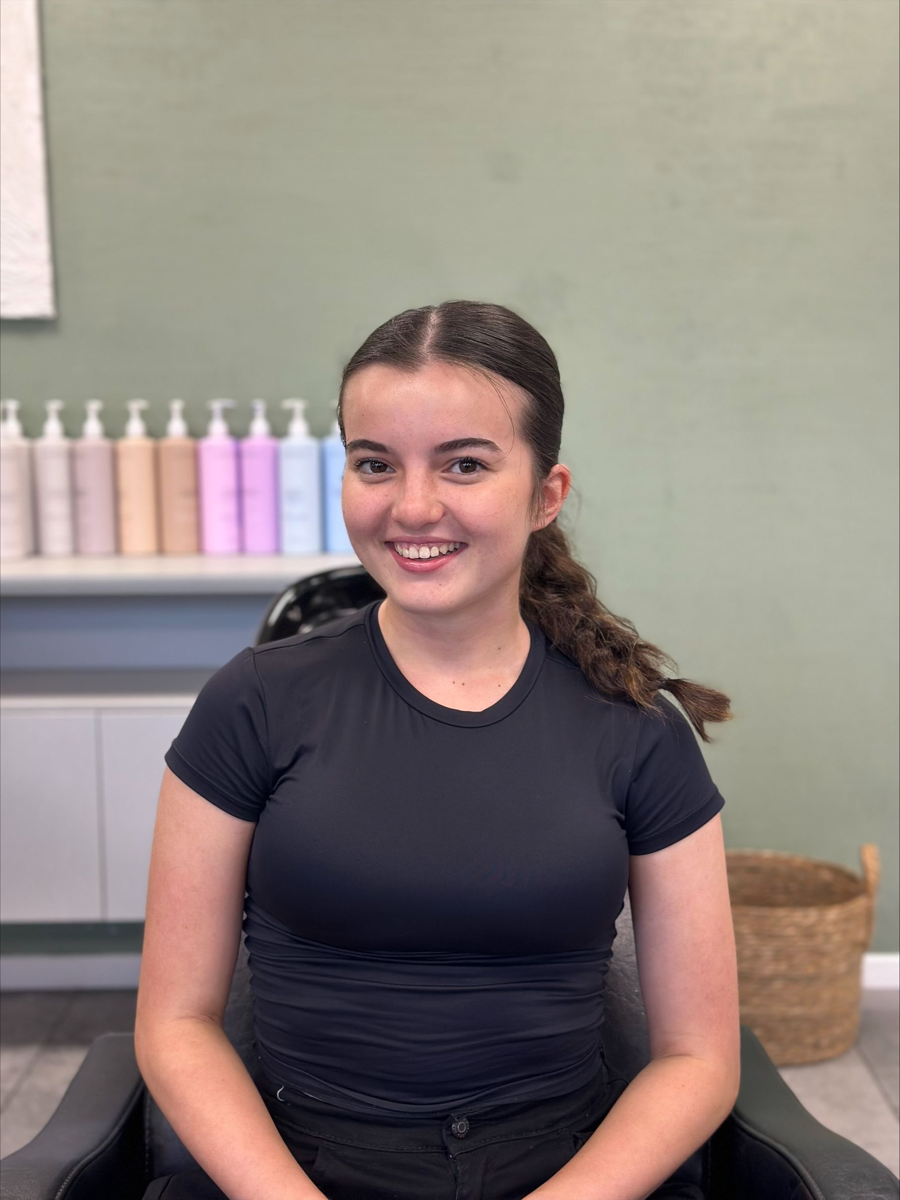 Young woman with dark hair and a smile in a salon setting — Fusion Hair In Woree, QLD
