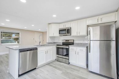 A kitchen with white cabinets and stainless steel appliances.