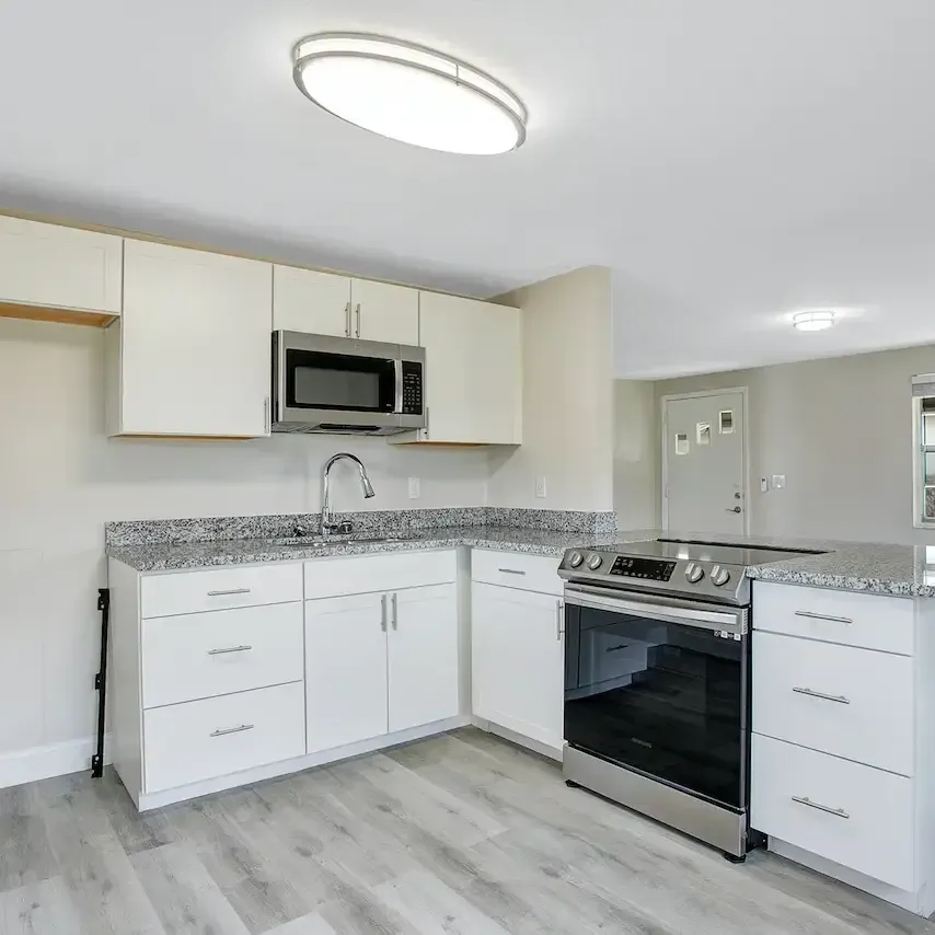 A kitchen with stainless steel appliances and white cabinets