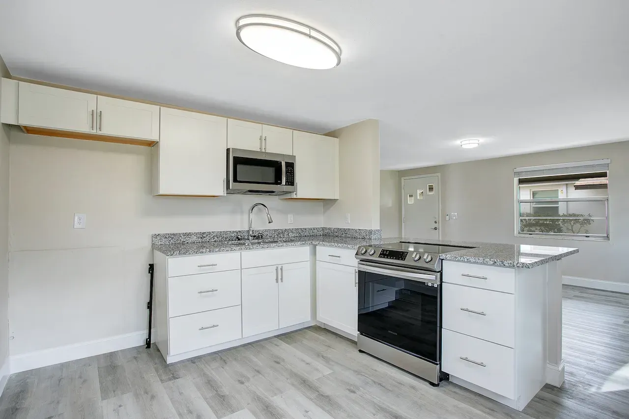 A kitchen with white cabinets and stainless steel appliances.