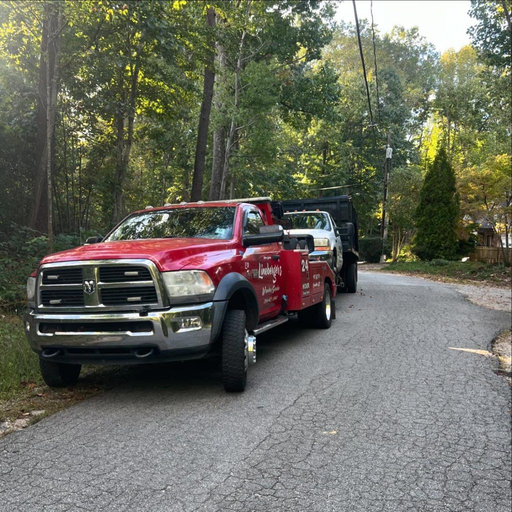 A red tow truck is parked on the side of a road.