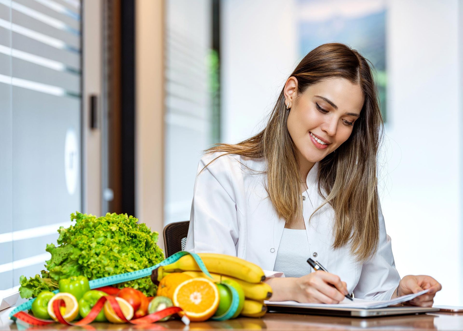 Woman Writing With Healthy Foods — Nicholson, PA — Optimal Whole Health & Nutrition