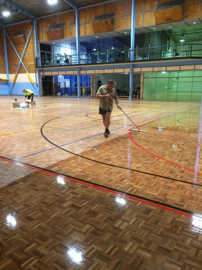 A Man Cleaning The Hardwood Floor - Custom Design Flooring in Alice Springs, NT