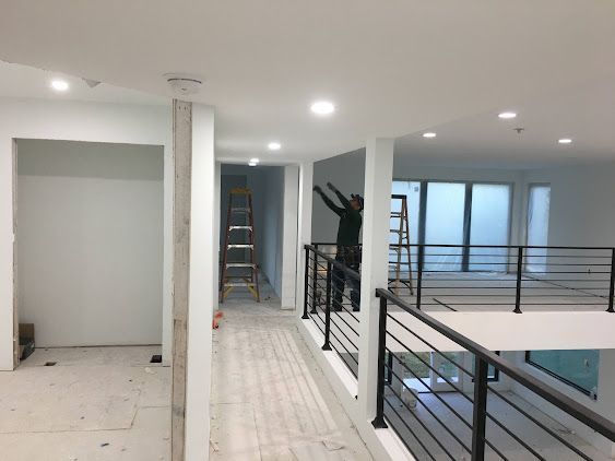 Mend Electric LLC - A man is standing on a balcony in an empty room.