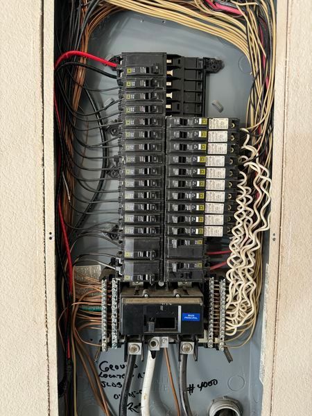 Mend Electric LLC - The inside of a electrical box with a lot of wires coming out of it.