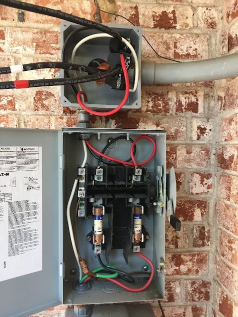 Mend Electric LLC - A box with wires coming out of it is on a brick wall.