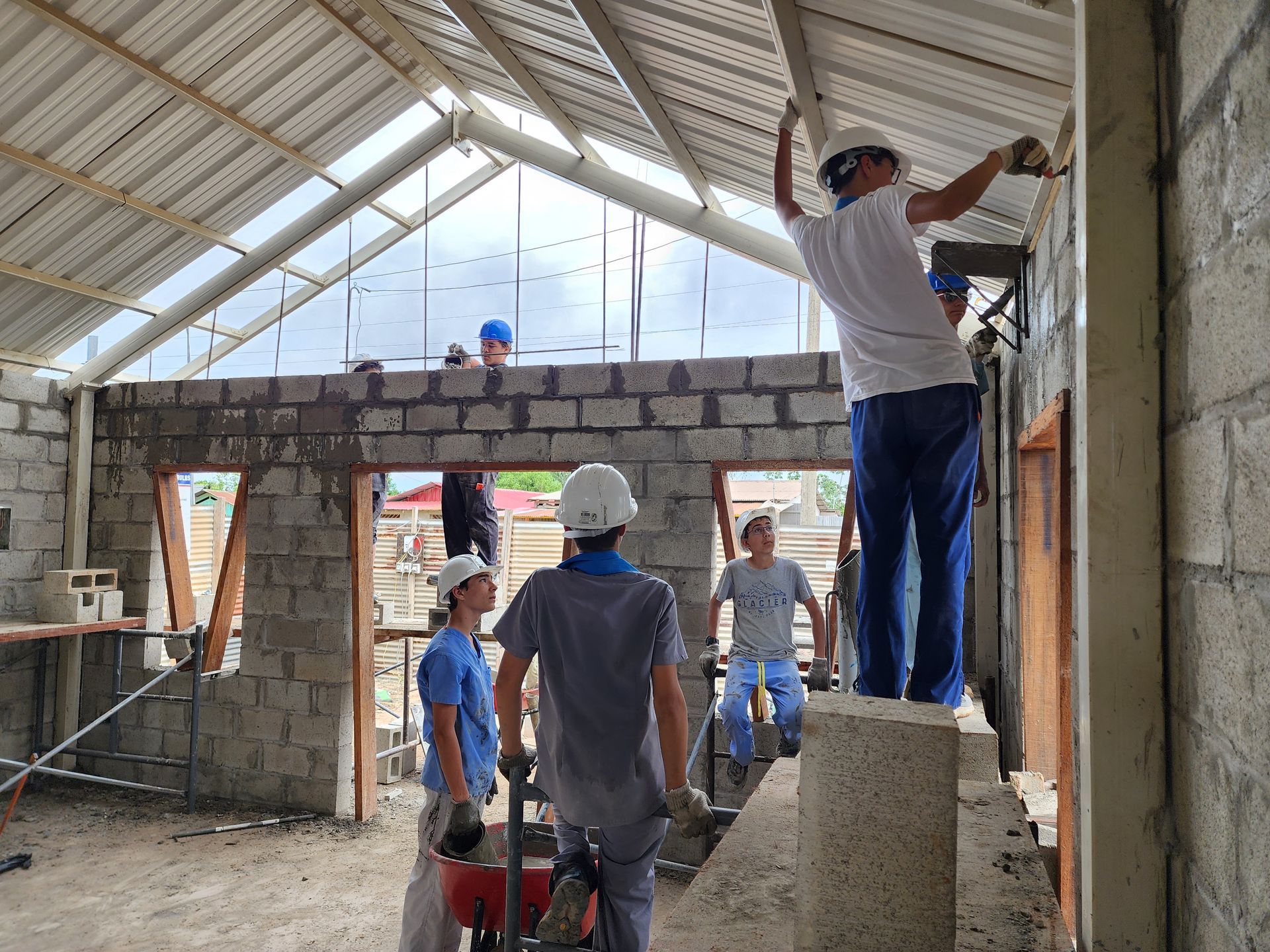 A group of student volunteer workers are working on a building.