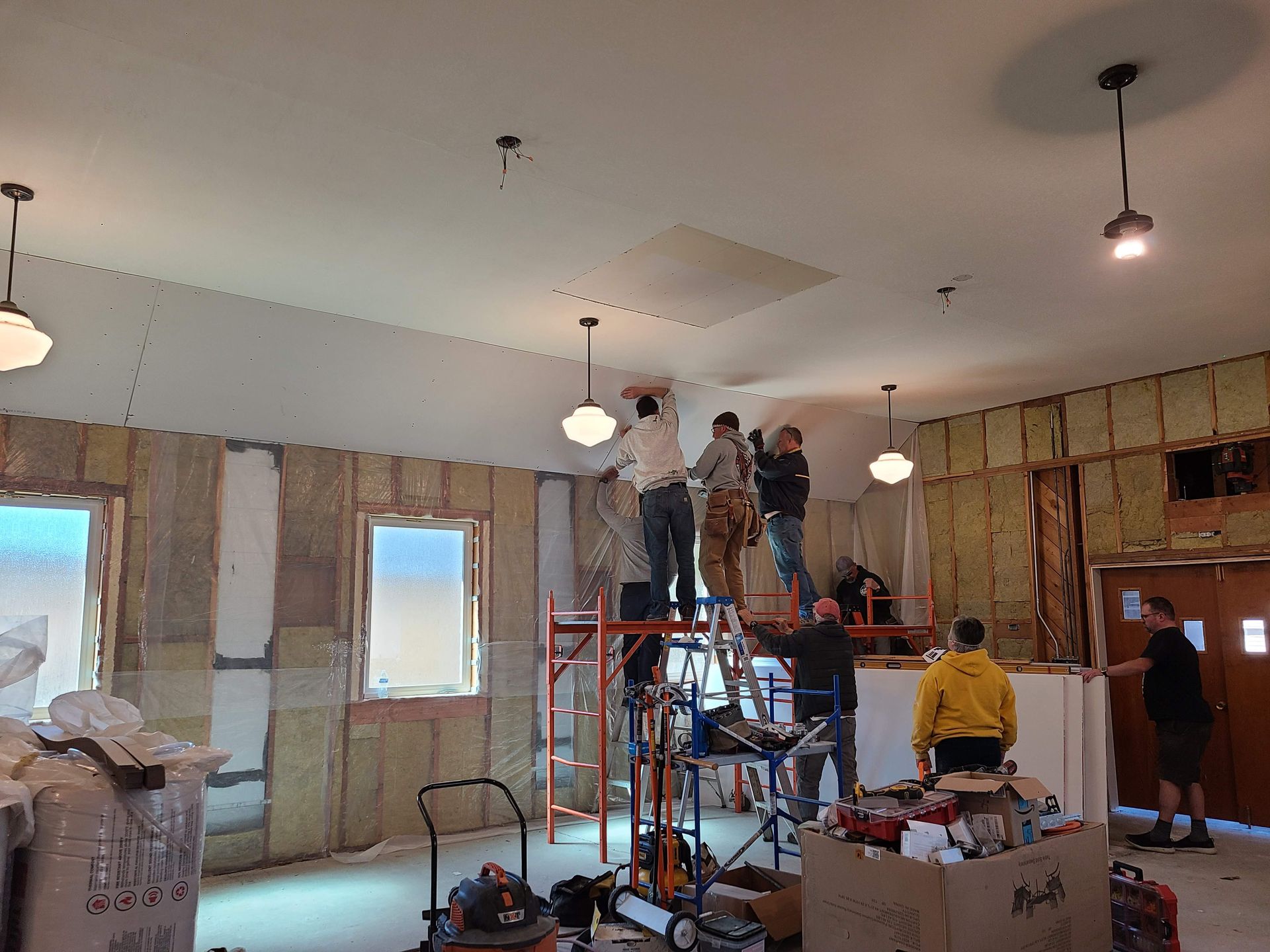 A group of volunteers putting up drywall inside the church