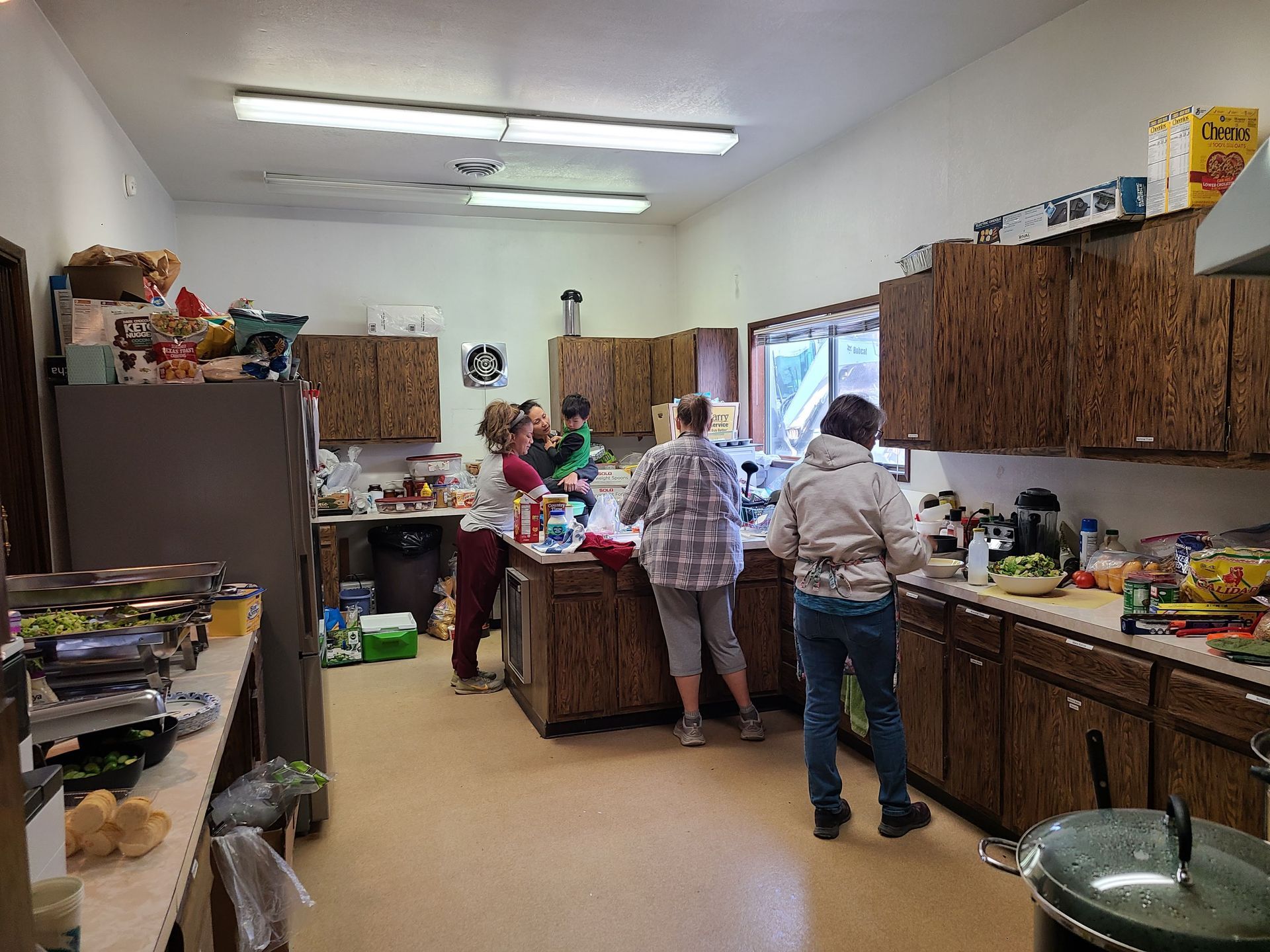 A group of people are standing in a kitchen preparing food.