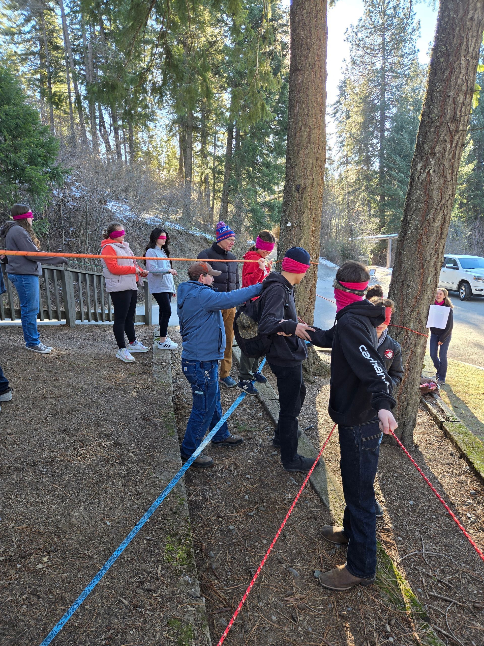 Pathfinders help each other through a blindfolded ropes course.