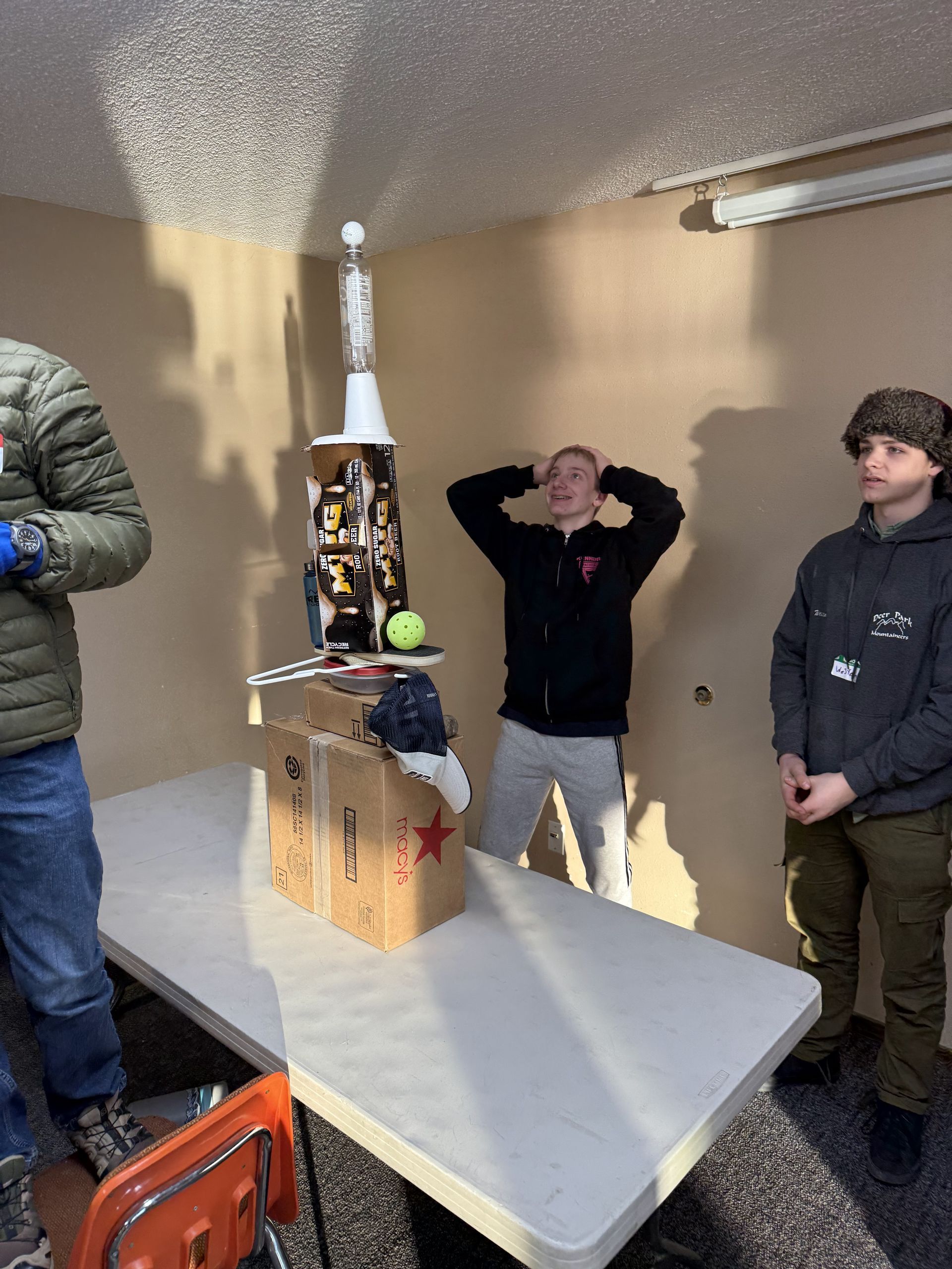 Teens work together to make a tower out of boxes.