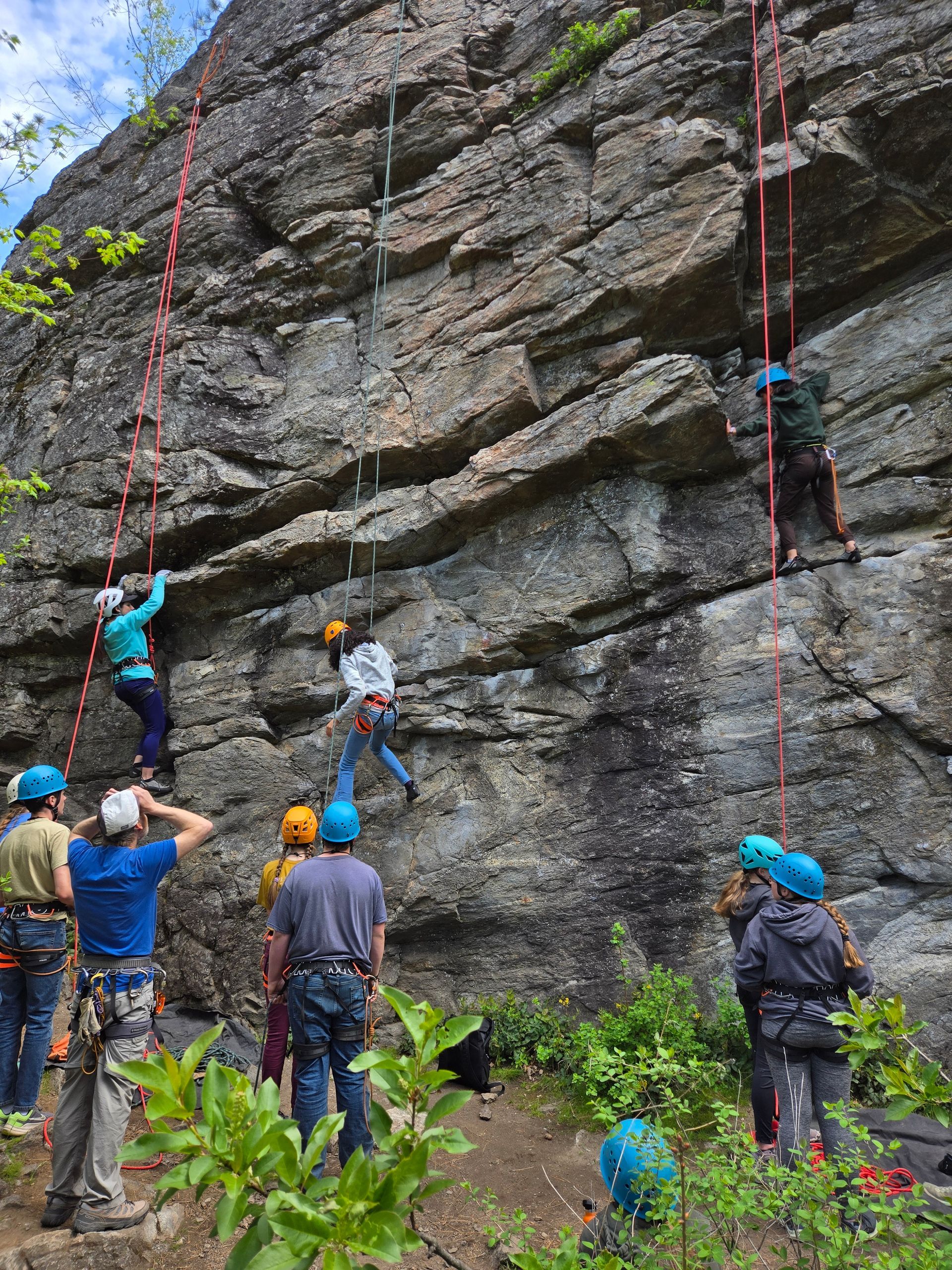 A group of people are descending a rock wall.