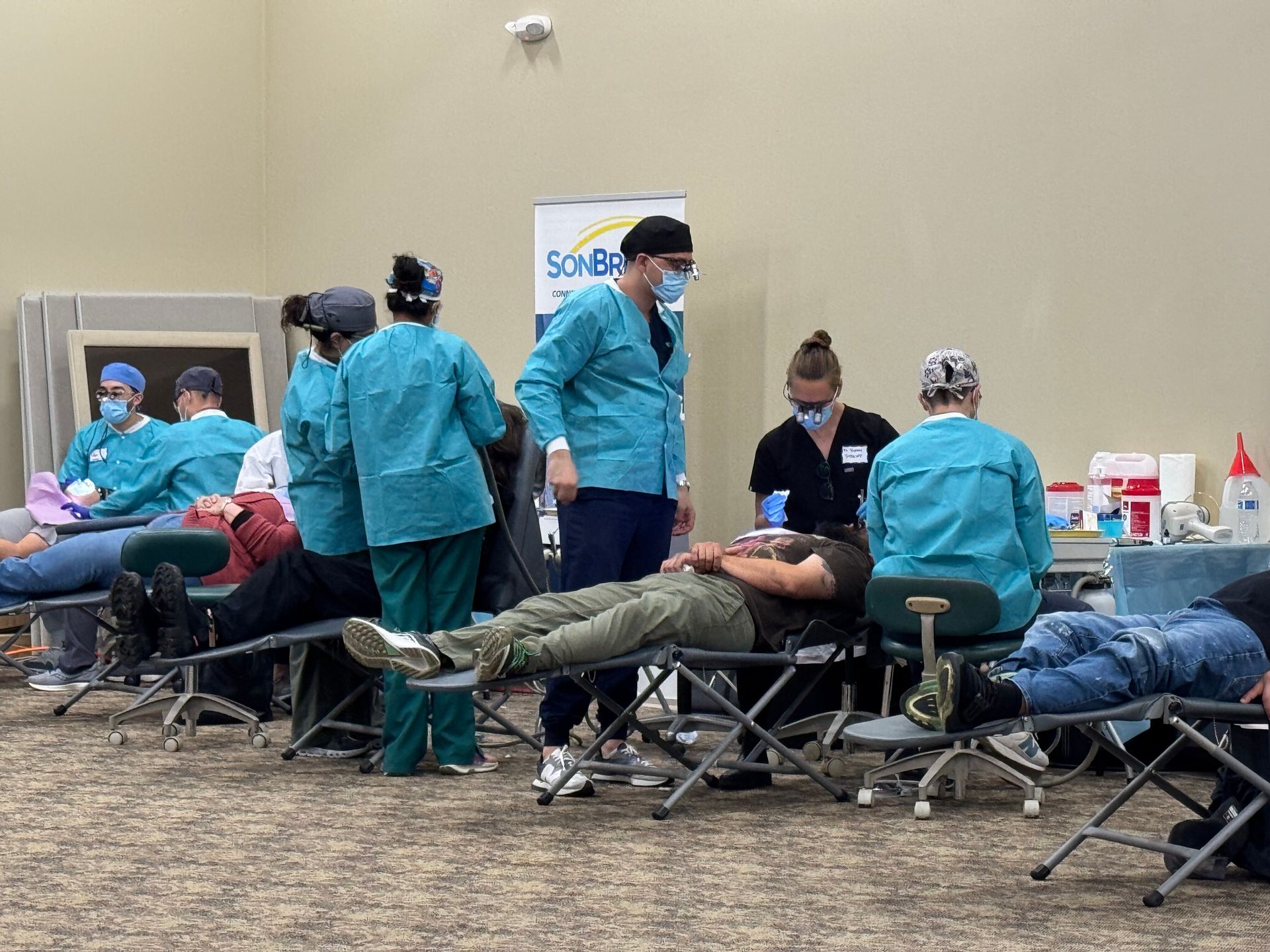A group of dental students observing and aiding in dental procedures