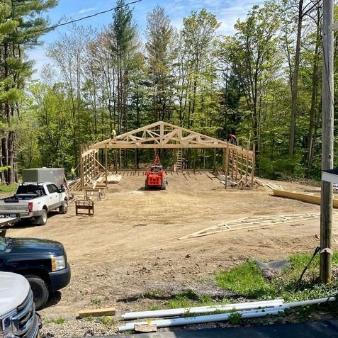 A large wooden structure is being built in the middle of a dirt field.