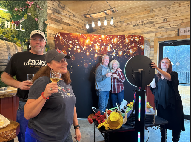 A group of people are posing for a picture in front of a photo booth.