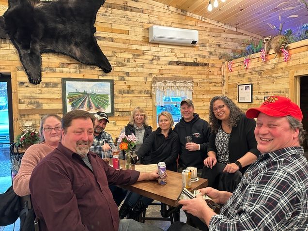 A group of people are sitting around a table in a room.