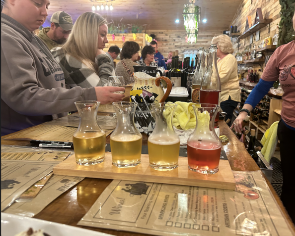 A group of people sitting at a table with a tray of beer on it
