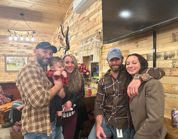 A group of people are posing for a picture in a living room.