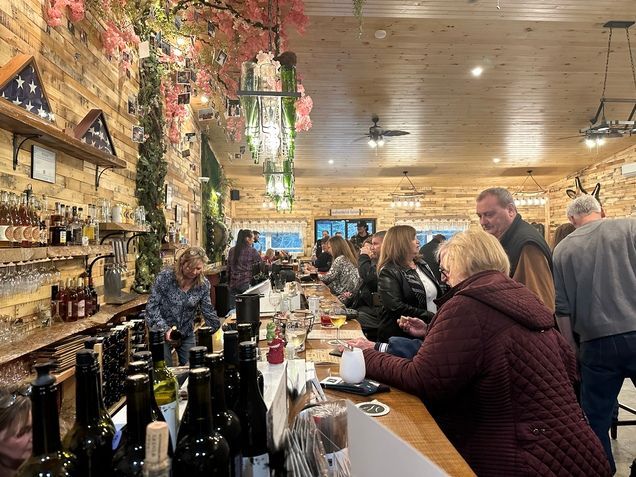 A group of people are sitting at a bar in a restaurant.