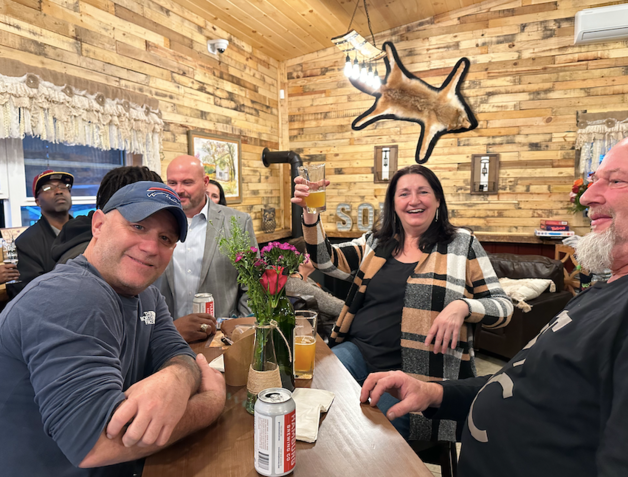 A group of people are sitting at a bar in a restaurant.