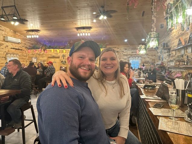 A man and a woman are sitting at a bar in a restaurant.