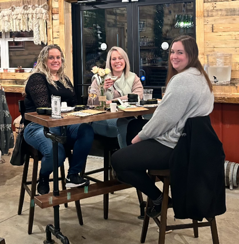 Three women are sitting at a table in a restaurant