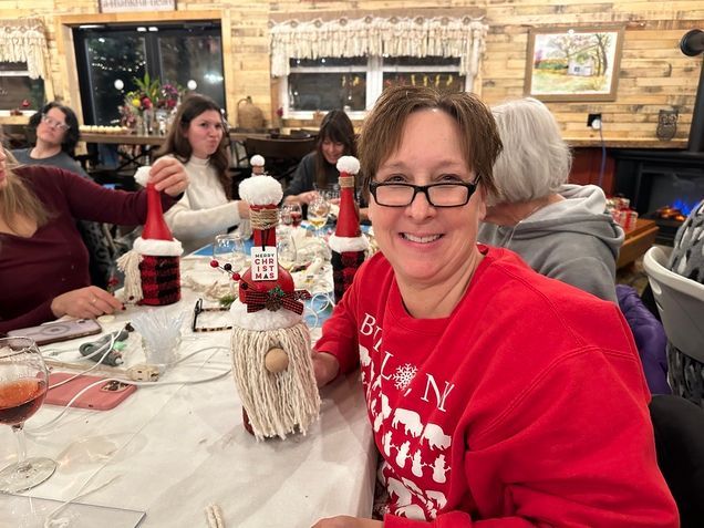 A woman in a red shirt is sitting at a table with a group of people.