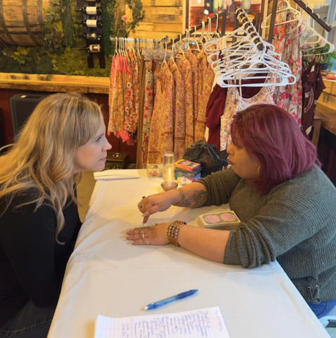 Two women are sitting at a table talking to each other