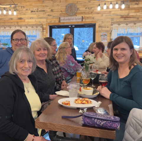 A group of women are sitting at a table with plates of food