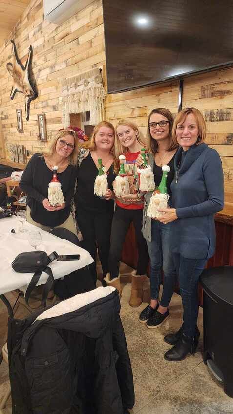 A group of women are standing next to each other in a room holding candles.