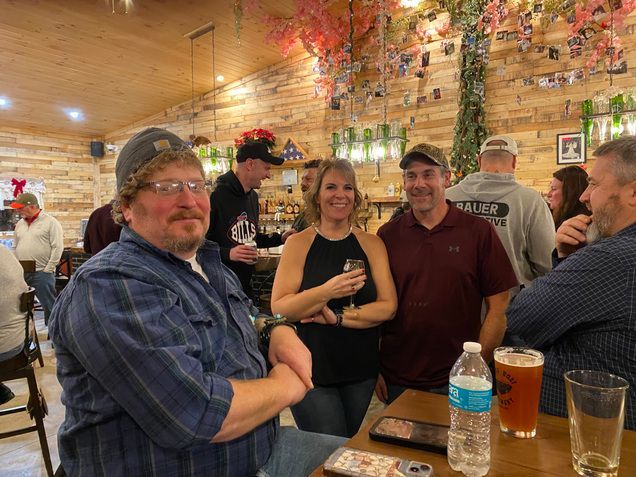 A group of people are standing around a table in a restaurant.