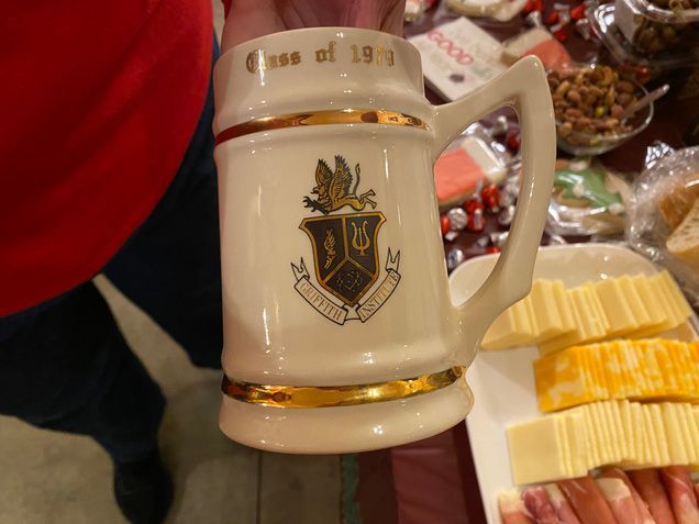 A person is holding a mug that says class of 1911