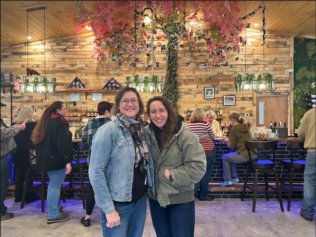 Two women are posing for a picture in a restaurant
