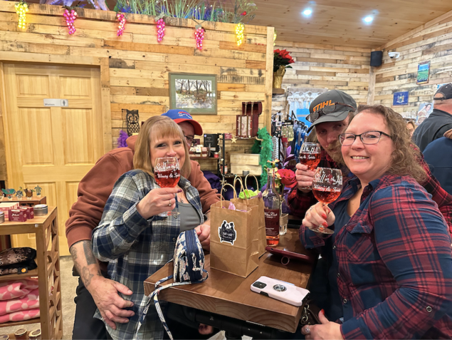 A group of people are sitting at a table drinking wine.