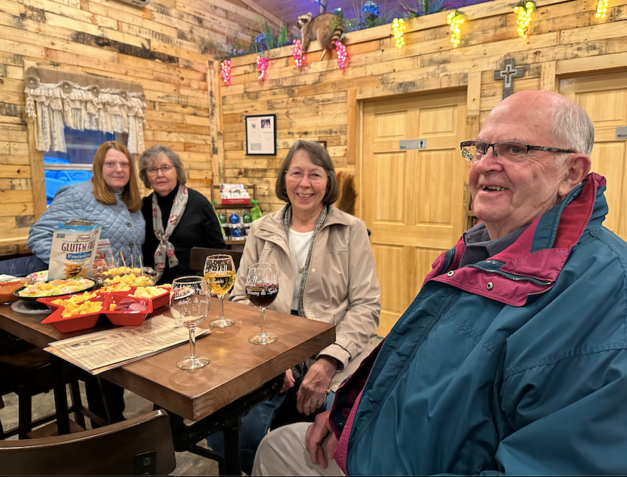 A group of people are sitting at a table with glasses of wine.