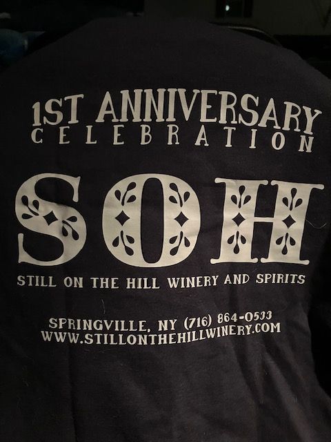 A black shirt that says 1st anniversary celebration soh still on the hill winery and spirits