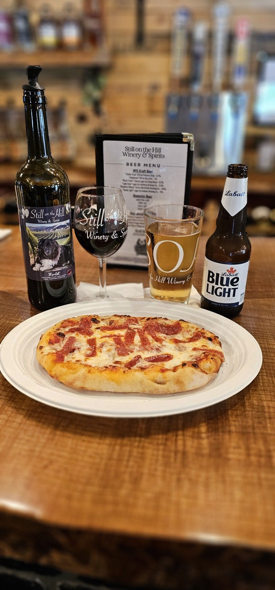 A bowl of french fries with guacamole and sour cream on a wooden cutting board.