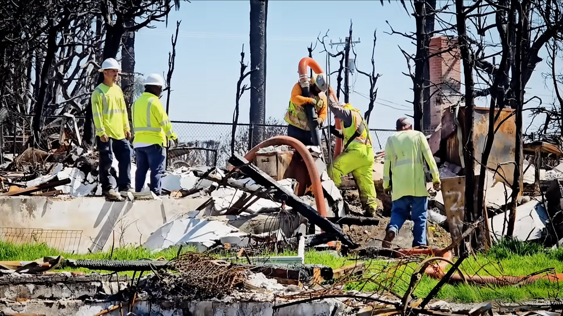 Fire damage restoration crew in safety gear working on a burnt down home in Pacific Palisades after severe fire damage.