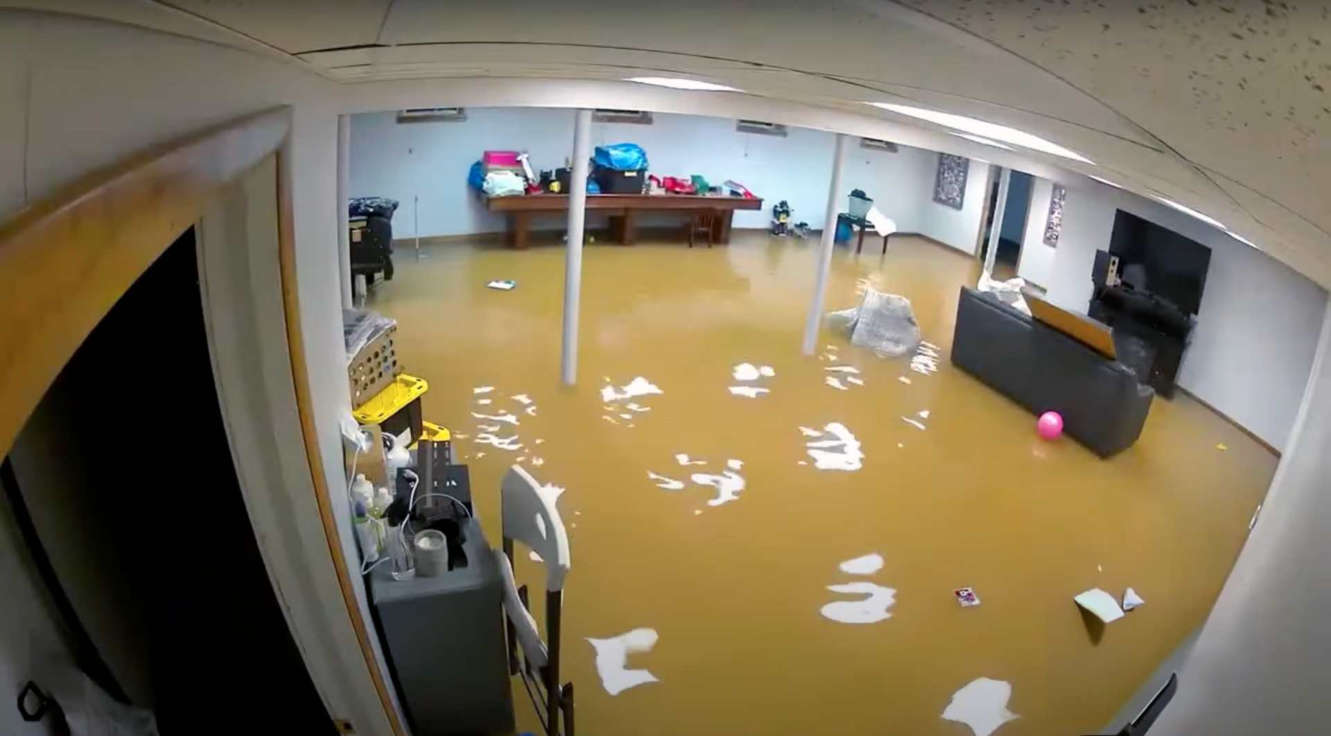 Flooded residential home in Newport Beach, CA with visible water damage on flooring and walls after heavy storm from Hurricane Hilary.