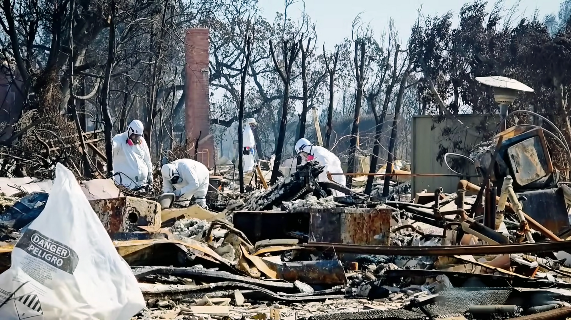 Water damage restoration crew wearing Tyvek suits and gas masks, repairing fire-damaged home in Pacific Palisades.