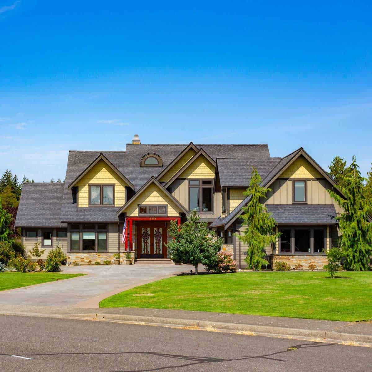 A large house with a lush green lawn in front of it.